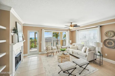 a living room with furniture a fireplace and a floor to ceiling window
