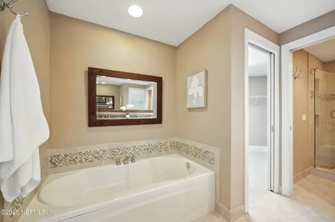 a white bath tub sitting next to a small bathroom