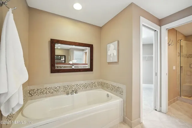 a white bath tub sitting next to a small bathroom