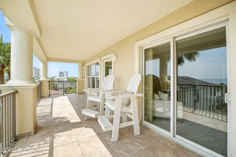 a living room with a patio fireplace and a dining table next to a window