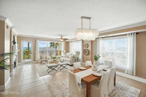 a living room with furniture a large window and chandelier
