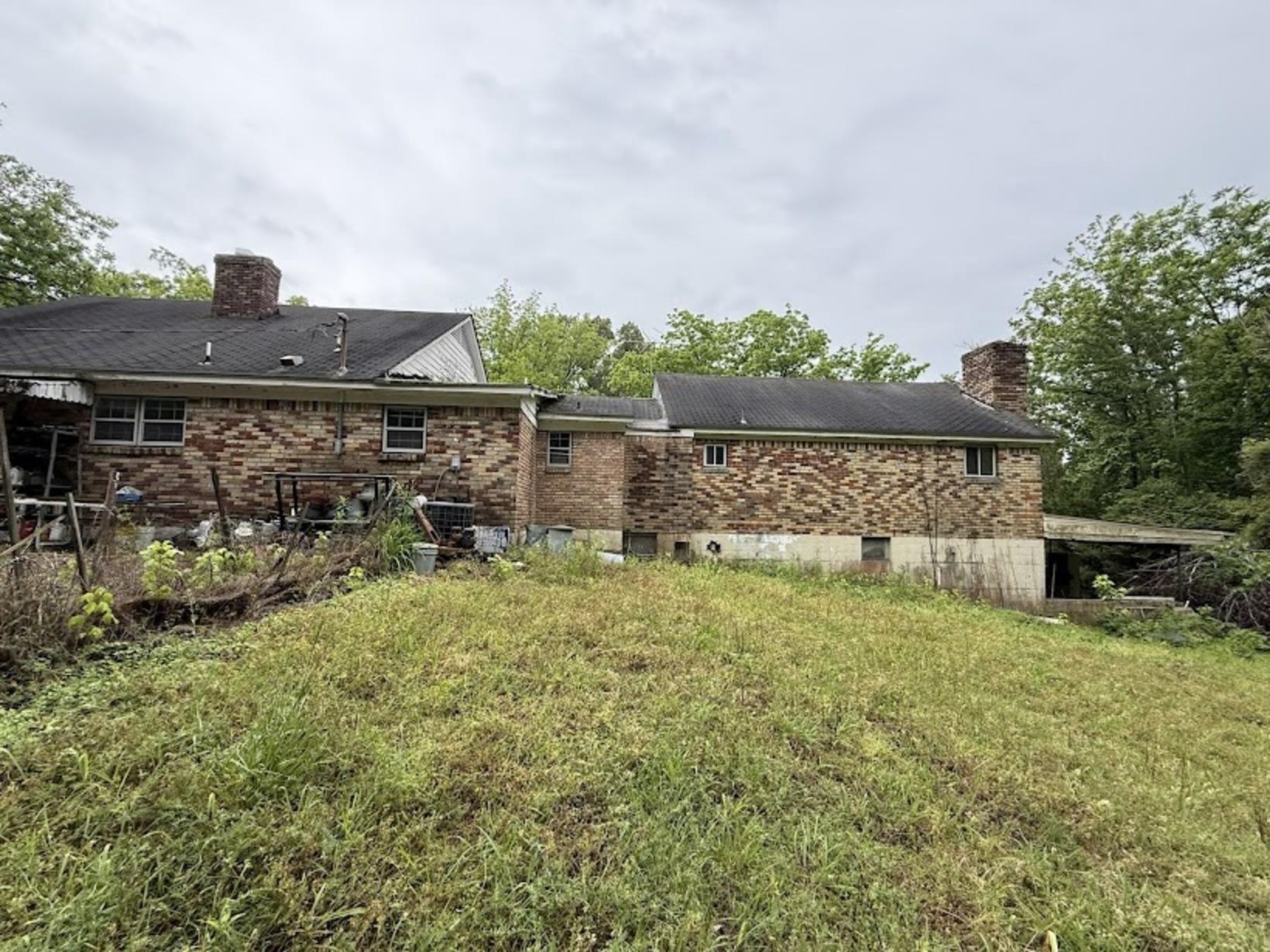 7280 Walsh Road Millington, TN 38053 - Photo 32 of 34 Brick exterior residence featuring multiple windows, a prominent brick chimney, and a dark shingle roof