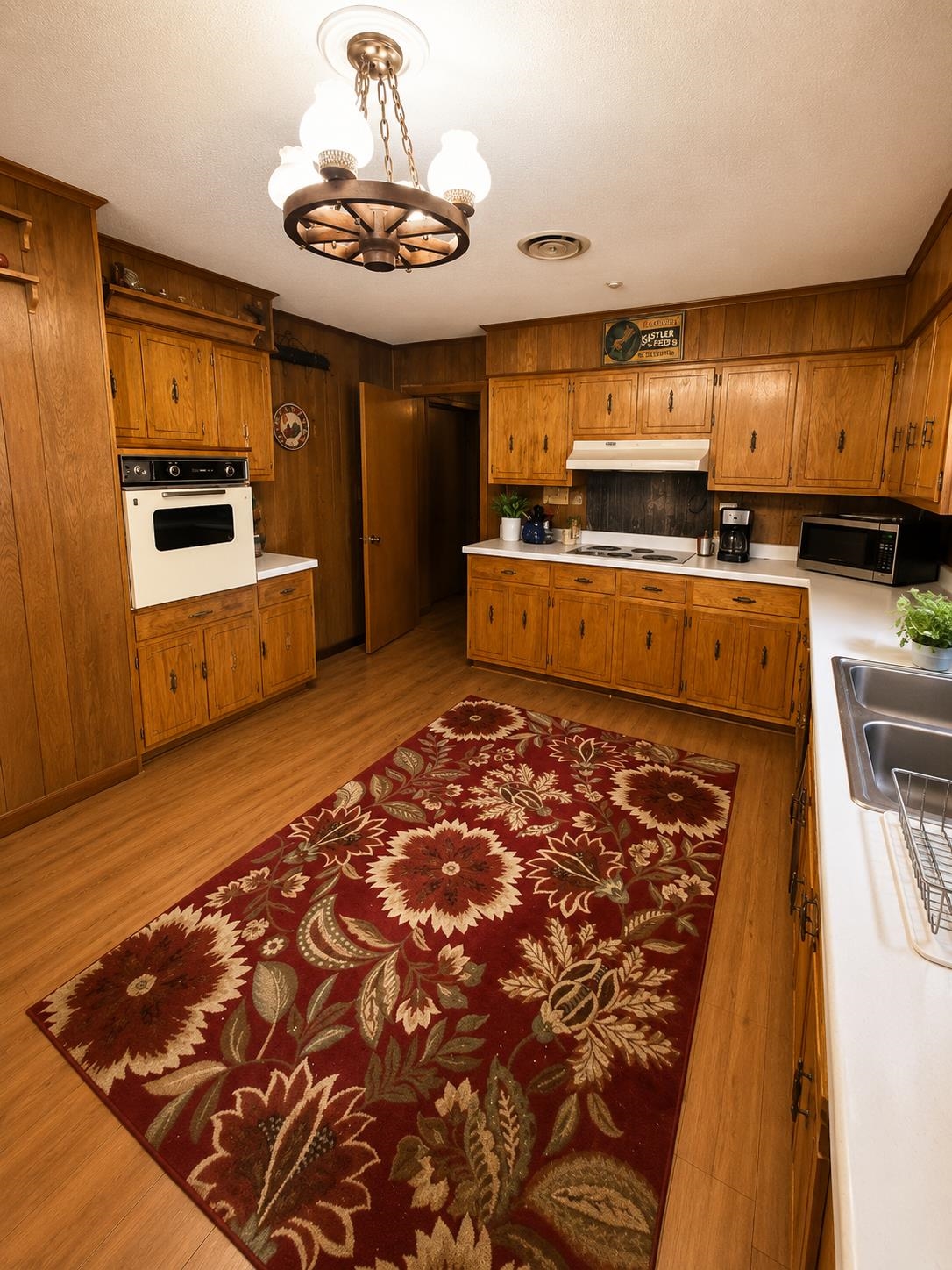7280 Walsh Road Millington, TN 38053 - Photo 4 of 34 Kitchen featuring wood-panel walls, wood-finish flooring, ample cabinetry, white countertops, and a built-in oven