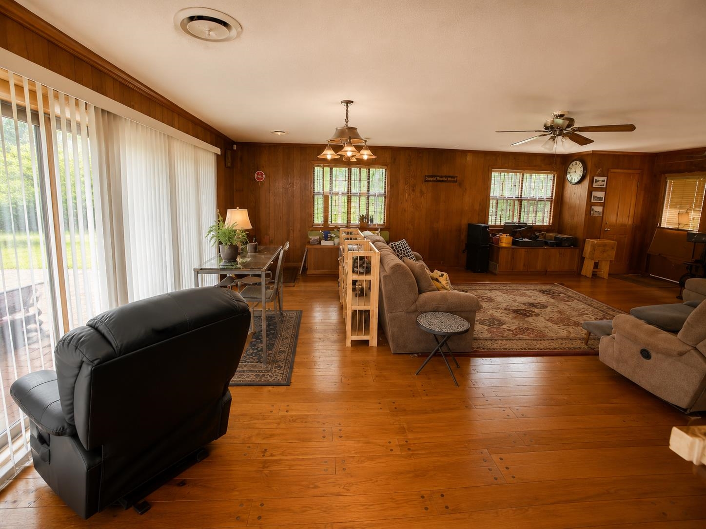 7280 Walsh Road Millington, TN 38053 - Photo 8 of 34 Spacious room featuring wood-finish flooring, wood-paneled walls, multiple windows, and a ceiling fan