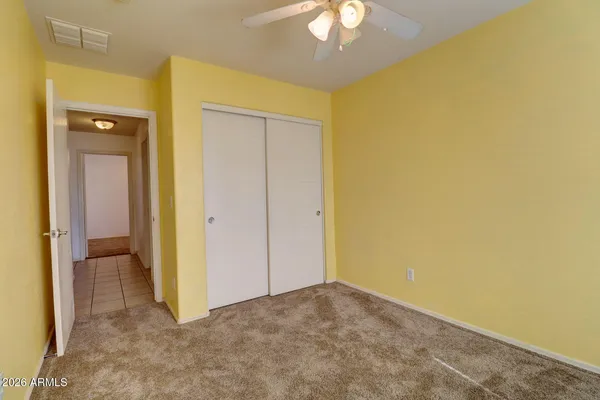 a view of an empty room with a chandelier fan