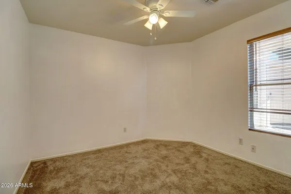 an empty room with a chandelier fan
