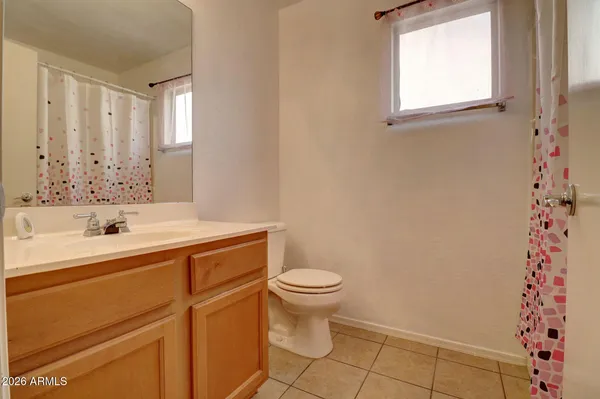 a bathroom with a sink a toilet and a window