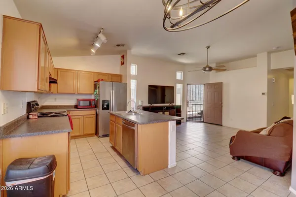 a kitchen with stainless steel appliances kitchen island granite countertop a sink and a stove top oven a granite counter space