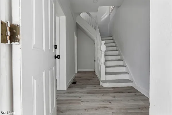 a view of a hallway with wooden floor and closet