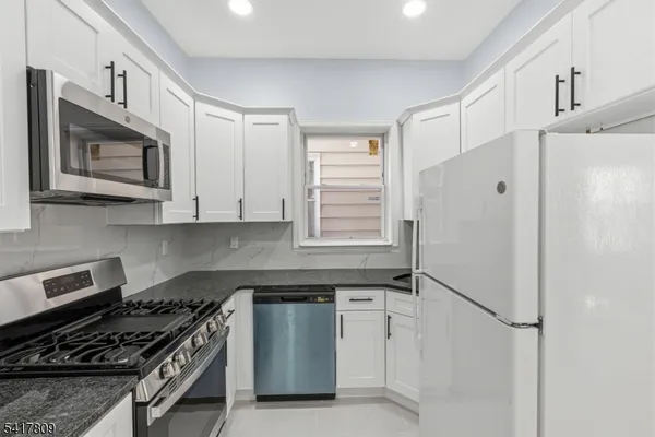 a kitchen with stainless steel appliances a stove a refrigerator and cabinets