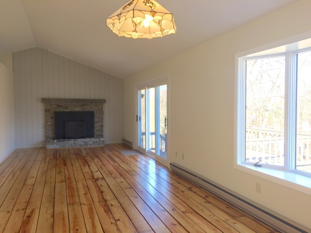 23 Stagecoach Road Amherst, MA 01002 - Photo 16 of 26 an empty room with wooden floor chandelier and windows
