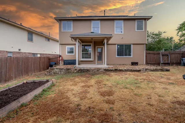 a view of a house with yard and wooden fence