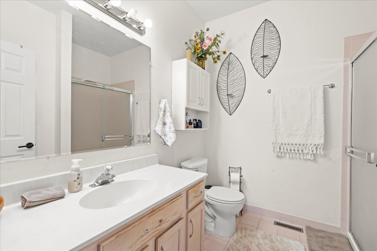 8025 Barrymore Drive Darien, IL 60561 - Photo 19 of 31 a bathroom with a sink a toilet and a mirror