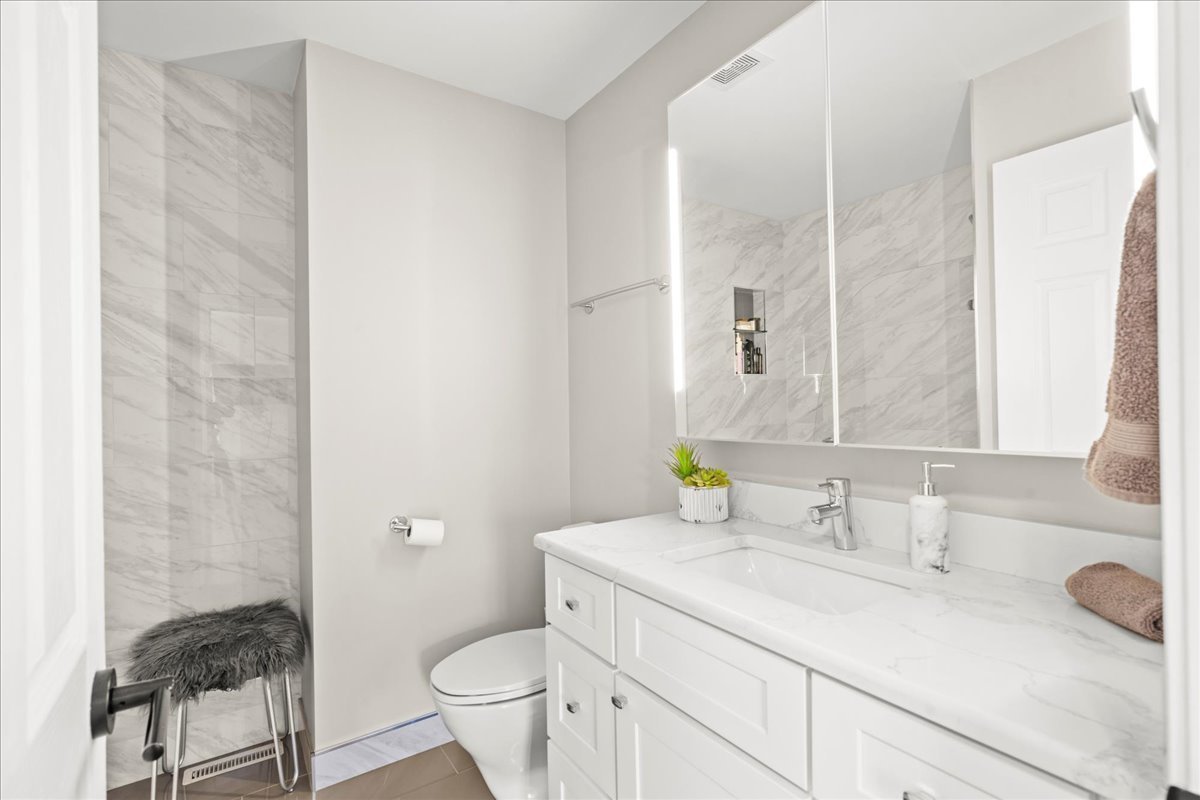 8025 Barrymore Drive Darien, IL 60561 - Photo 21 of 31 a bathroom with a granite countertop sink a toilet and a mirror