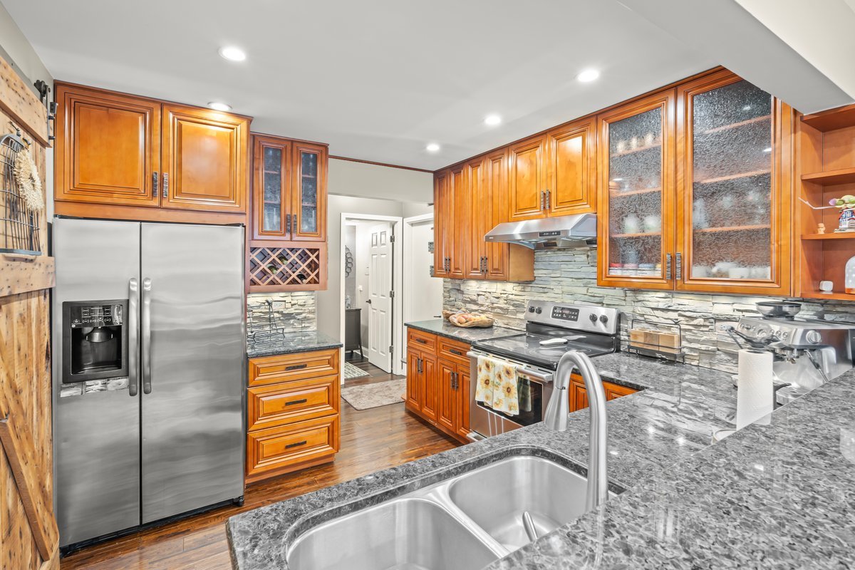 8025 Barrymore Drive Darien, IL 60561 - Photo 9 of 31 a kitchen with stainless steel appliances granite countertop a sink a stove and a refrigerator