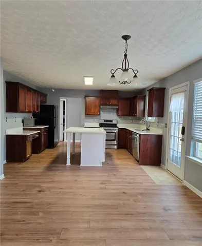 a large kitchen with stainless steel appliances granite countertop a stove and a sink