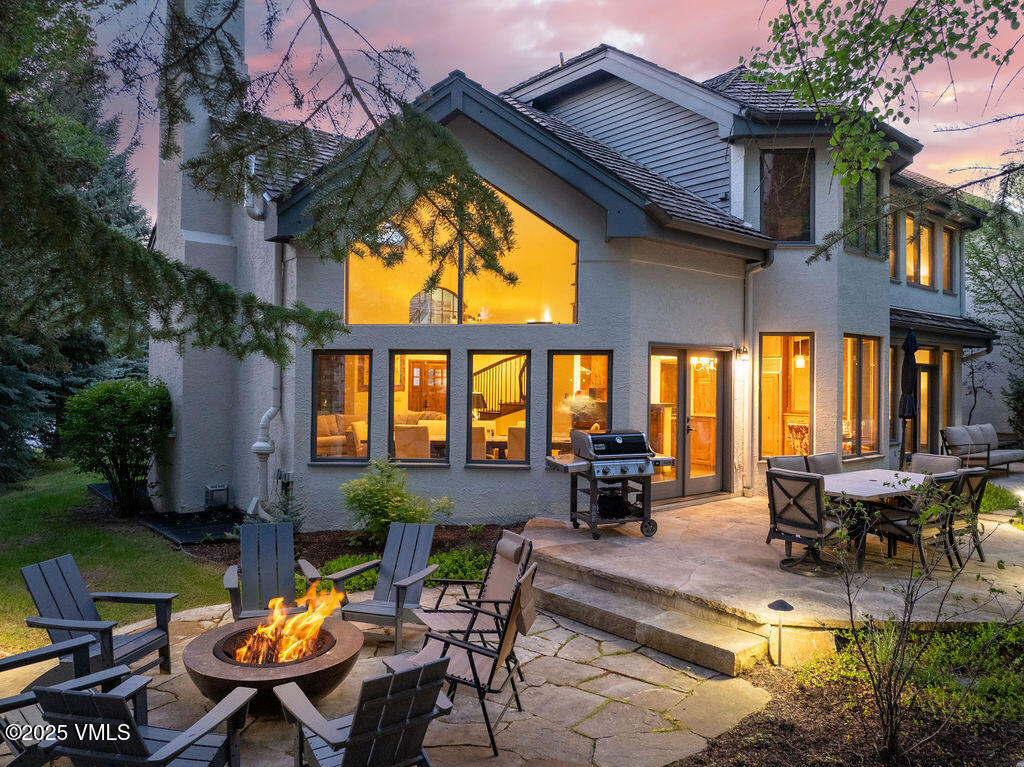 a view of a patio with table and chairs potted plants and a large tree