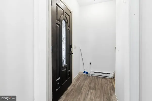 a view of a hallway with wooden floor and closet