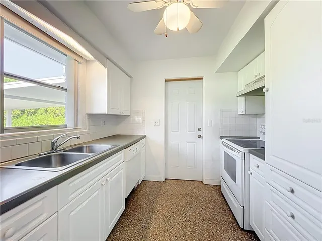 a kitchen with stainless steel appliances granite countertop white cabinets a sink and dishwasher