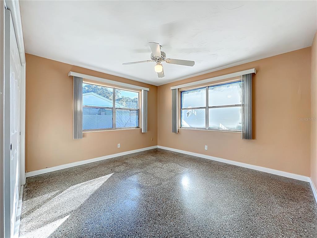 1401 Orange Tree Drive Edgewater, FL 32132 - Photo 22 of 46 an empty room with windows and ceiling fan