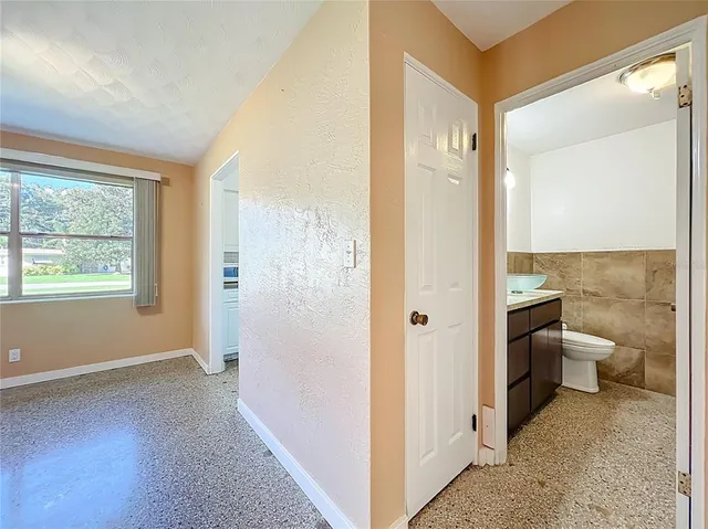 a bathroom with a granite countertop sink a toilet and mirror