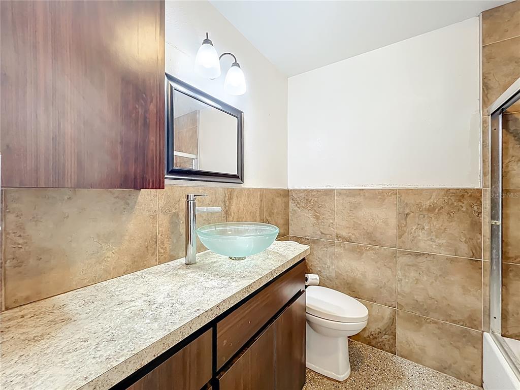 1401 Orange Tree Drive Edgewater, FL 32132 - Photo 27 of 46 a bathroom with a granite countertop sink a toilet and mirror