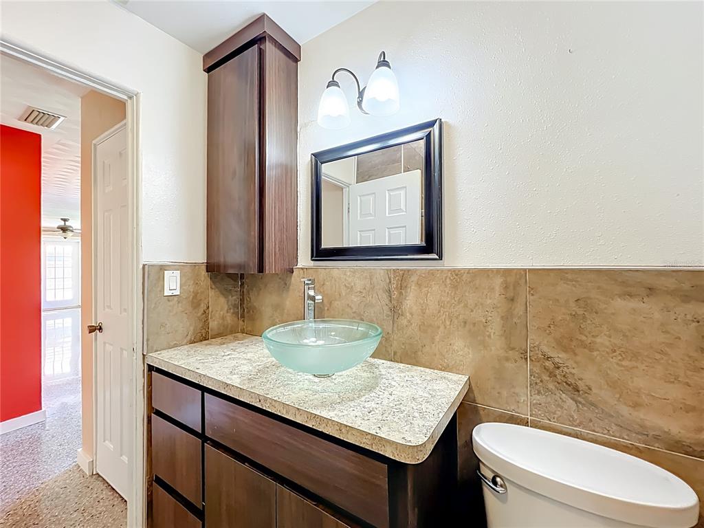 1401 Orange Tree Drive Edgewater, FL 32132 - Photo 30 of 46 a bathroom with a granite countertop toilet sink and mirror