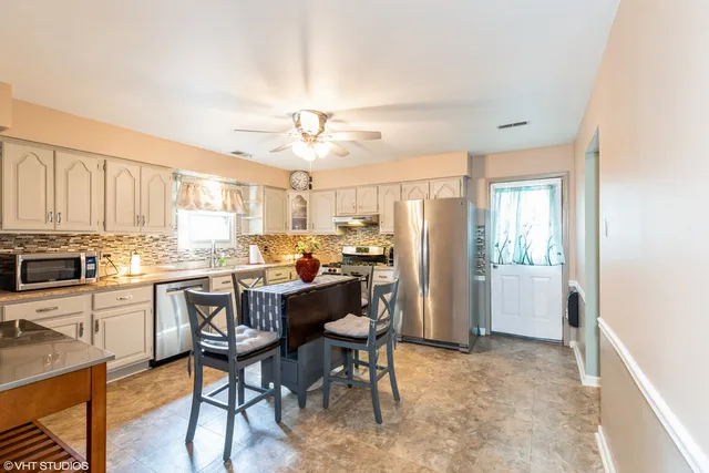 a kitchen with kitchen island a dining table and chairs