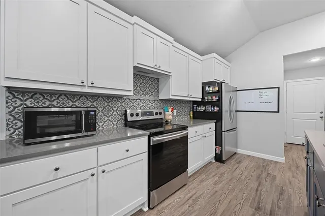 a kitchen with kitchen island granite countertop a sink a counter space stainless steel appliances and cabinets