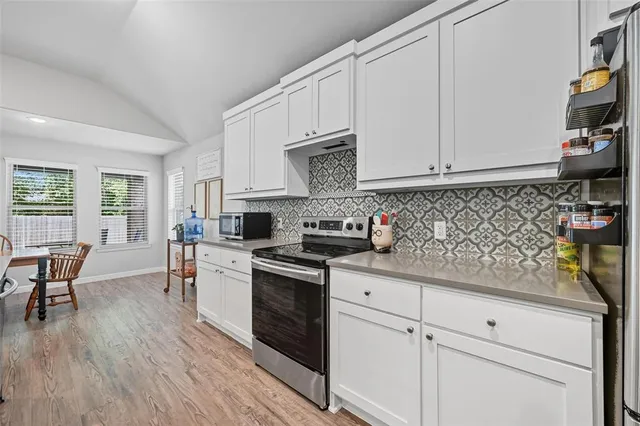 a large living room with stainless steel appliances granite countertop a couch and a flat screen tv