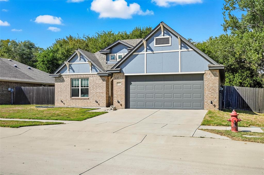 977 Sam Street Springtown, TX 76082 - Photo 2 of 29 a front view of a house with a yard and garage