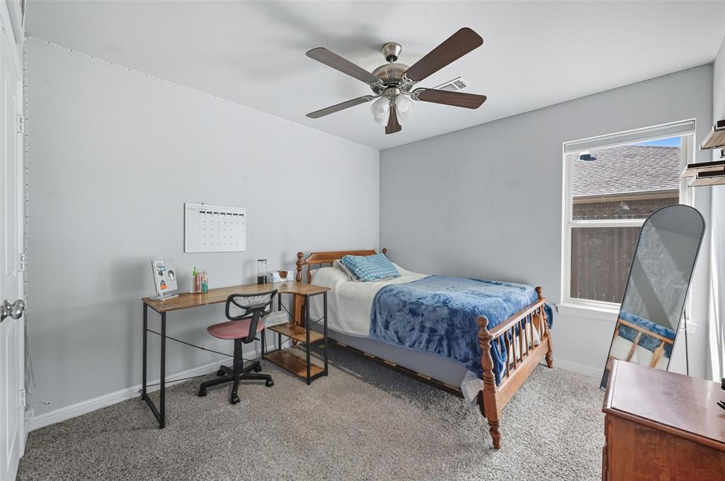 977 Sam Street Springtown, TX 76082 - Photo 20 of 29 a bedroom with a bed a desk and chair