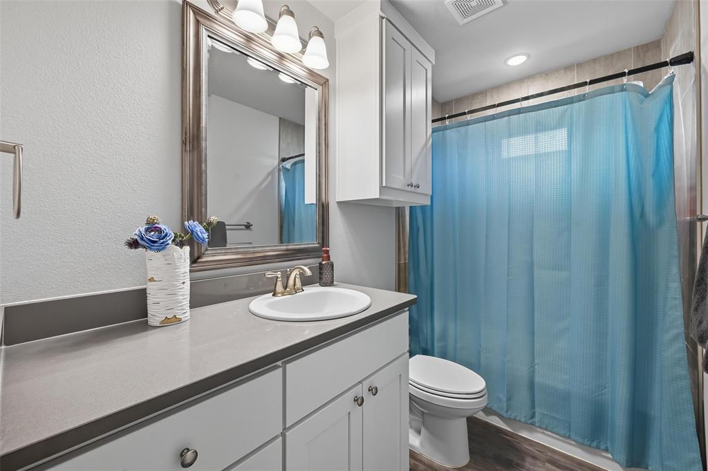 977 Sam Street Springtown, TX 76082 - Photo 22 of 29 a bathroom with a toilet a sink and mirror