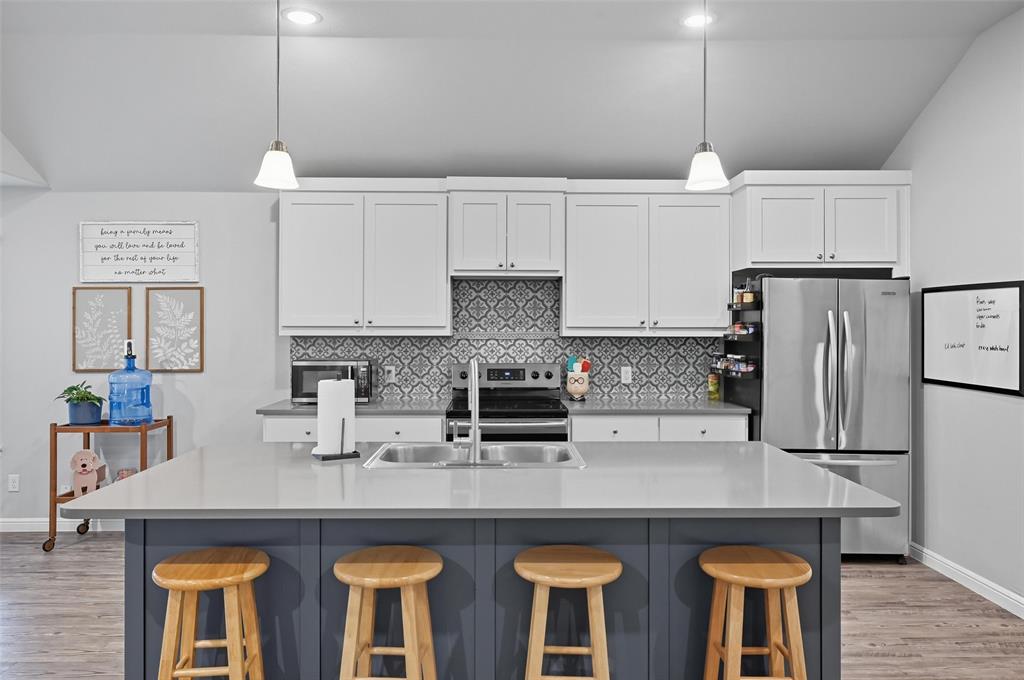 977 Sam Street Springtown, TX 76082 - Photo 9 of 29 a kitchen with stainless steel appliances granite countertop a sink a stove and a refrigerator