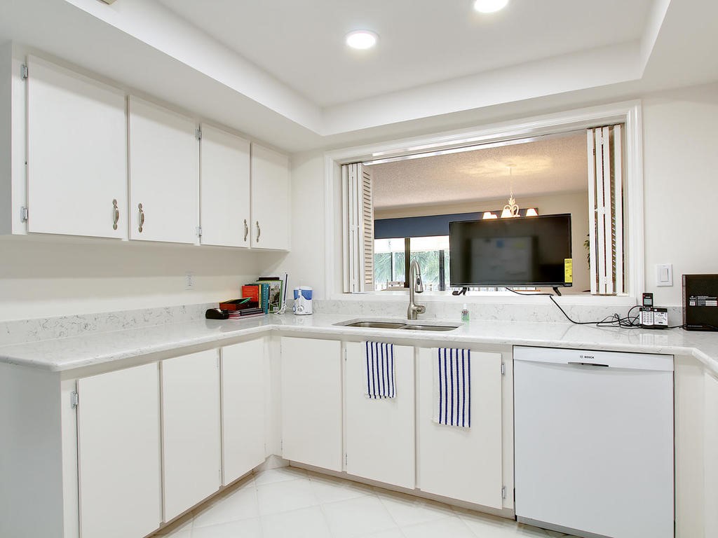 1880 Bay Road, Unit 220I Vero Beach, FL 32963 - Photo 11 of 35 a kitchen with white cabinets