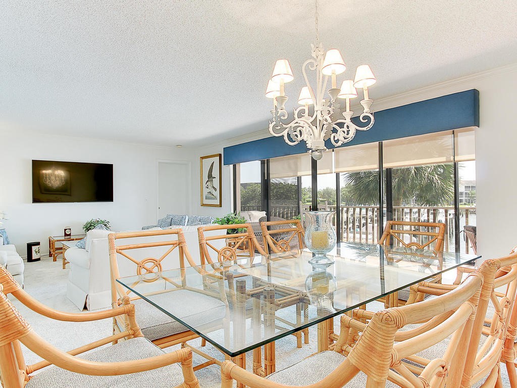 1880 Bay Road, Unit 220I Vero Beach, FL 32963 - Photo 9 of 35 a view of a dining room with furniture a chandelier and large windows