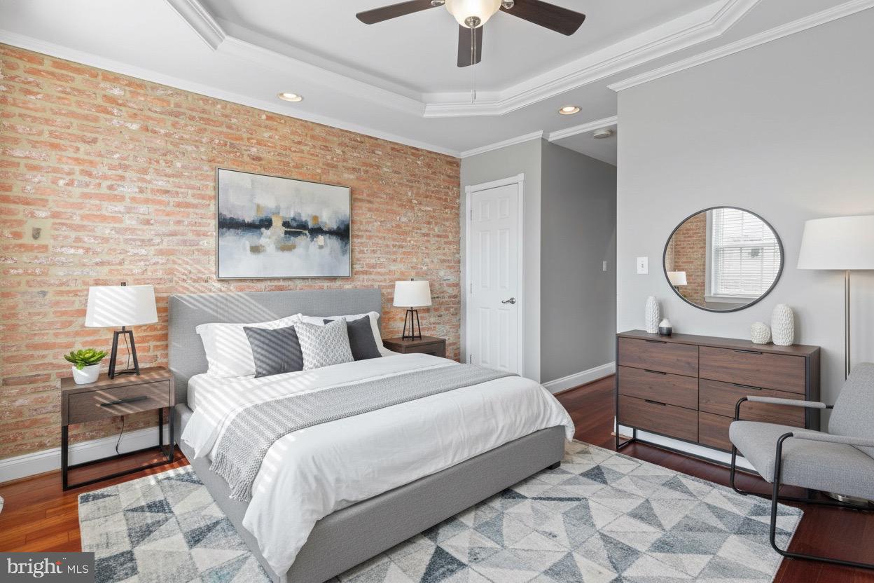 2428 Fleet Street Baltimore, MD 21224 - Photo 12 of 24 a bedroom with a bed mirror and a chandelier