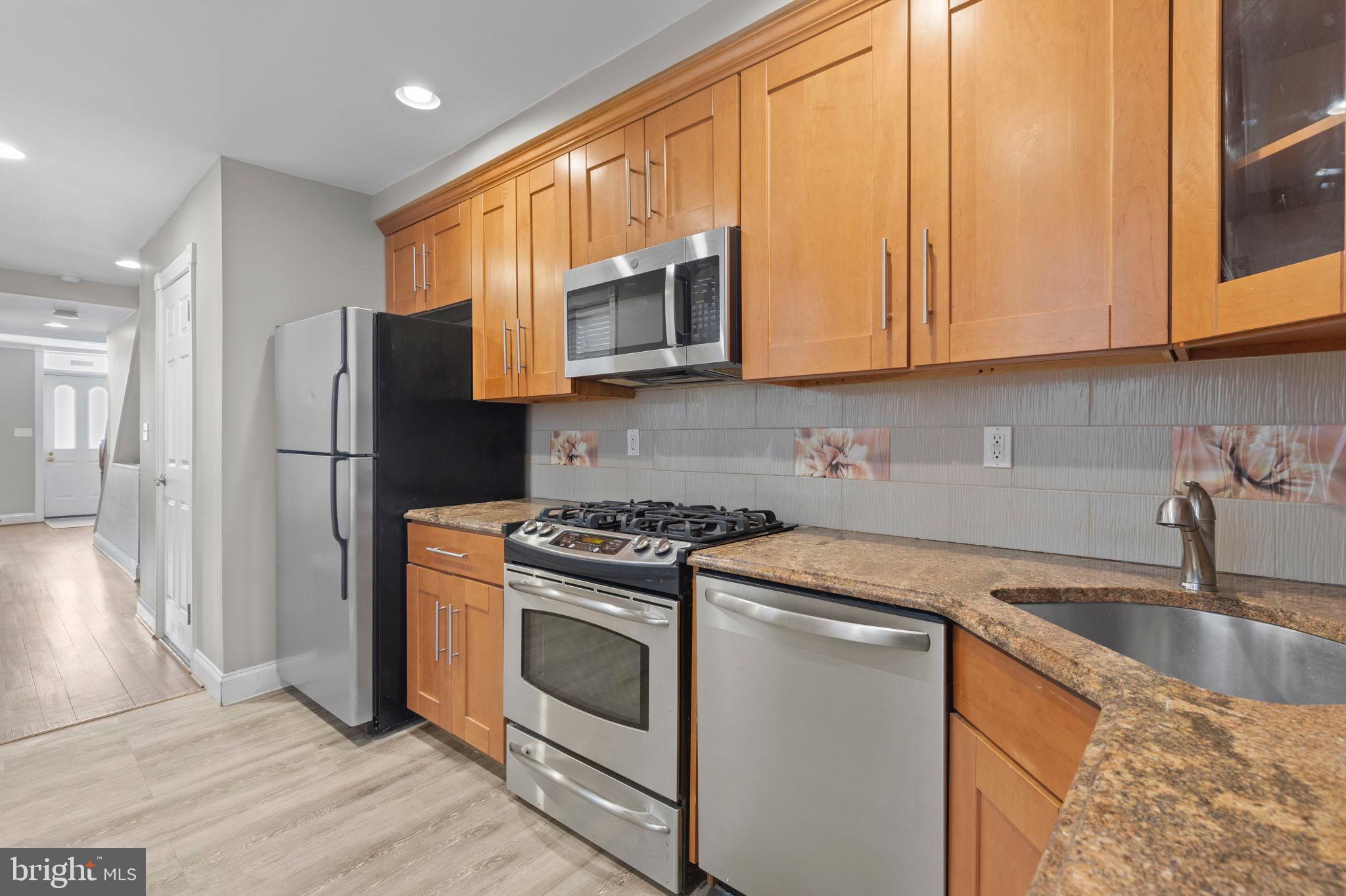 2428 Fleet Street Baltimore, MD 21224 - Photo 7 of 24 a kitchen with stainless steel appliances granite countertop a refrigerator stove and sink