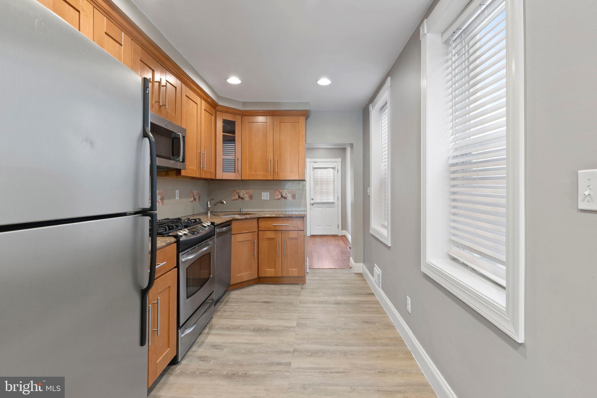 2428 Fleet Street Baltimore, MD 21224 - Photo 8 of 24 a kitchen with granite countertop a refrigerator and a stove