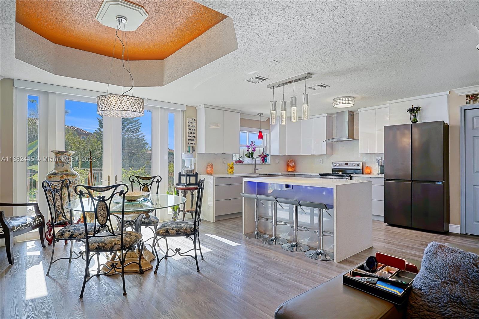 3078 Southwest 153rd Path, Unit 3078 Miami, FL 33185 - Photo 3 of 36 a kitchen with stainless steel appliances granite countertop a dining table chairs refrigerator and sink