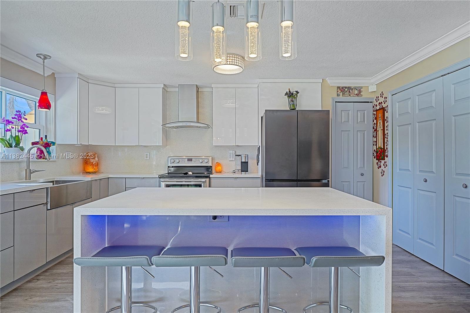 3078 Southwest 153rd Path, Unit 3078 Miami, FL 33185 - Photo 4 of 36 a kitchen with a refrigerator a stove a microwave a dining table and chairs