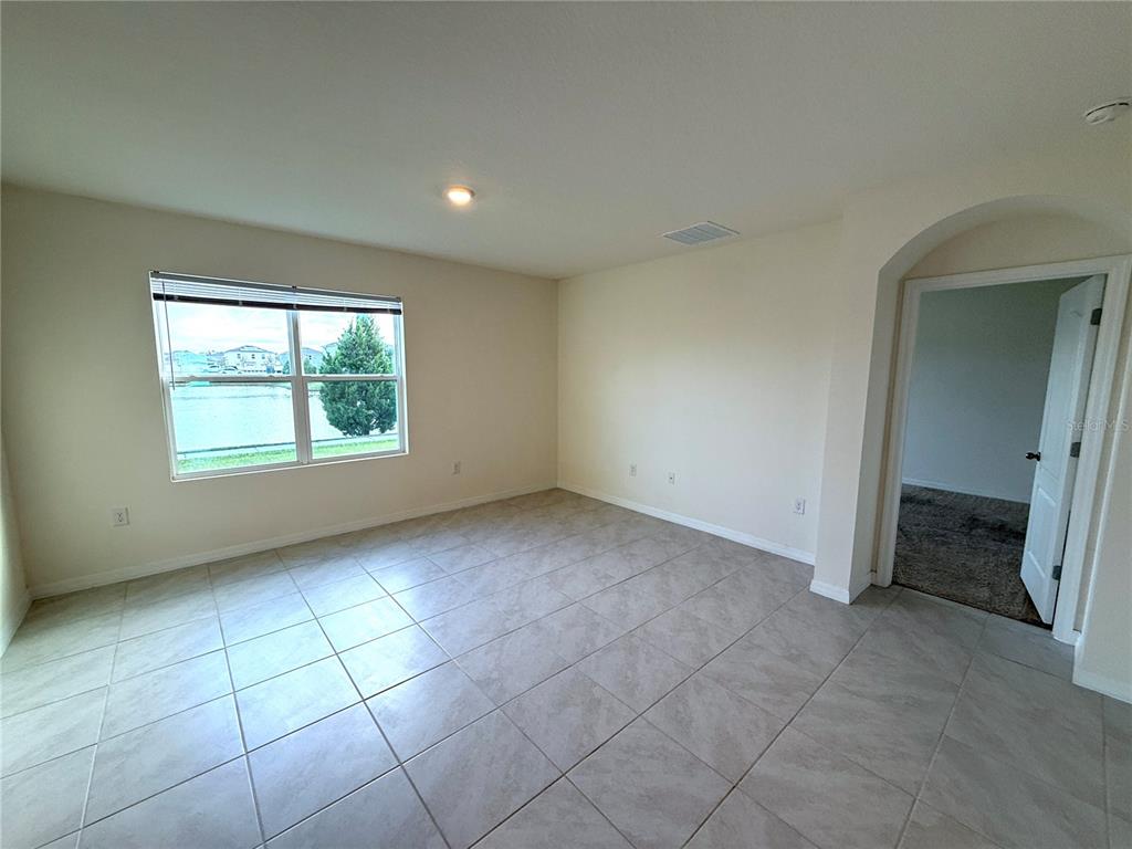 2877 Sunridge Loop St. Cloud, FL 34771 - Photo 5 of 19 an empty room with a fireplace and windows