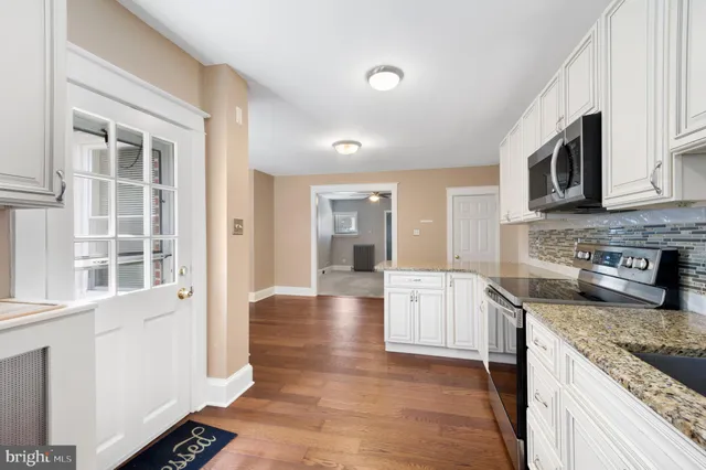 a large kitchen with stainless steel appliances granite countertop a stove and a sink