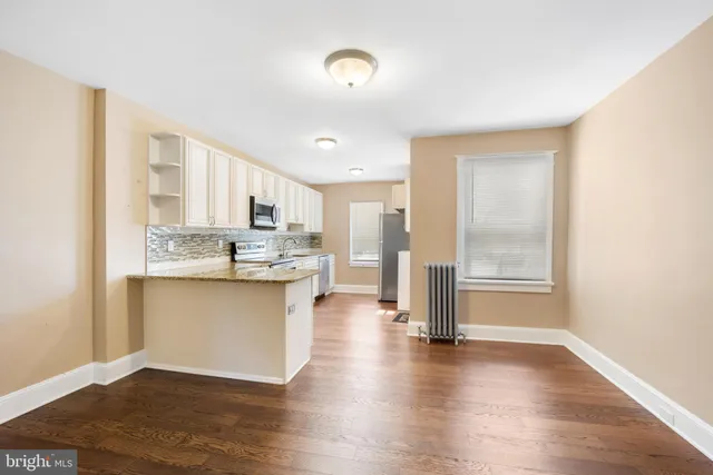 a kitchen with granite countertop a stove a sink and a refrigerator