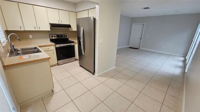 a kitchen with stainless steel appliances a refrigerator sink and cabinets