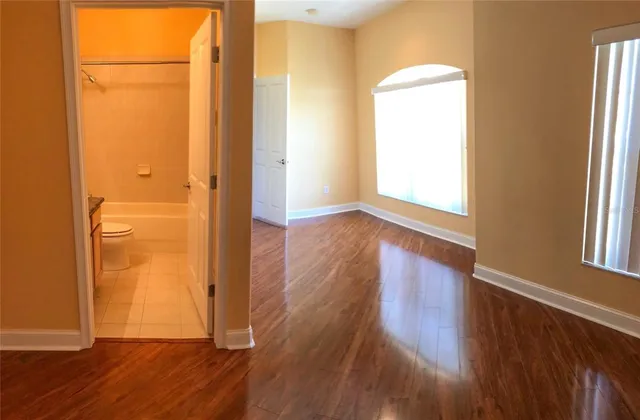 an empty room with wooden floor and closet