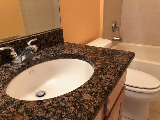 a bathroom with a granite countertop sink and a mirror