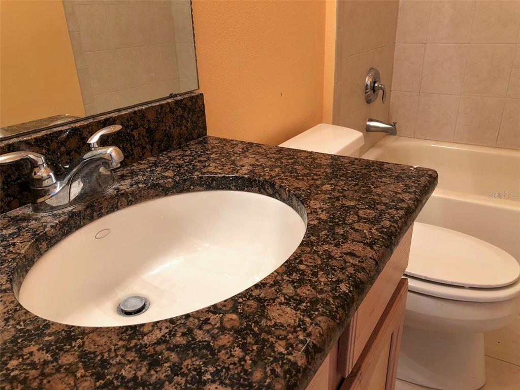 6517 Channelside Drive New Port Richey, FL 34652 - Photo 15 of 31 a bathroom with a granite countertop sink and a mirror