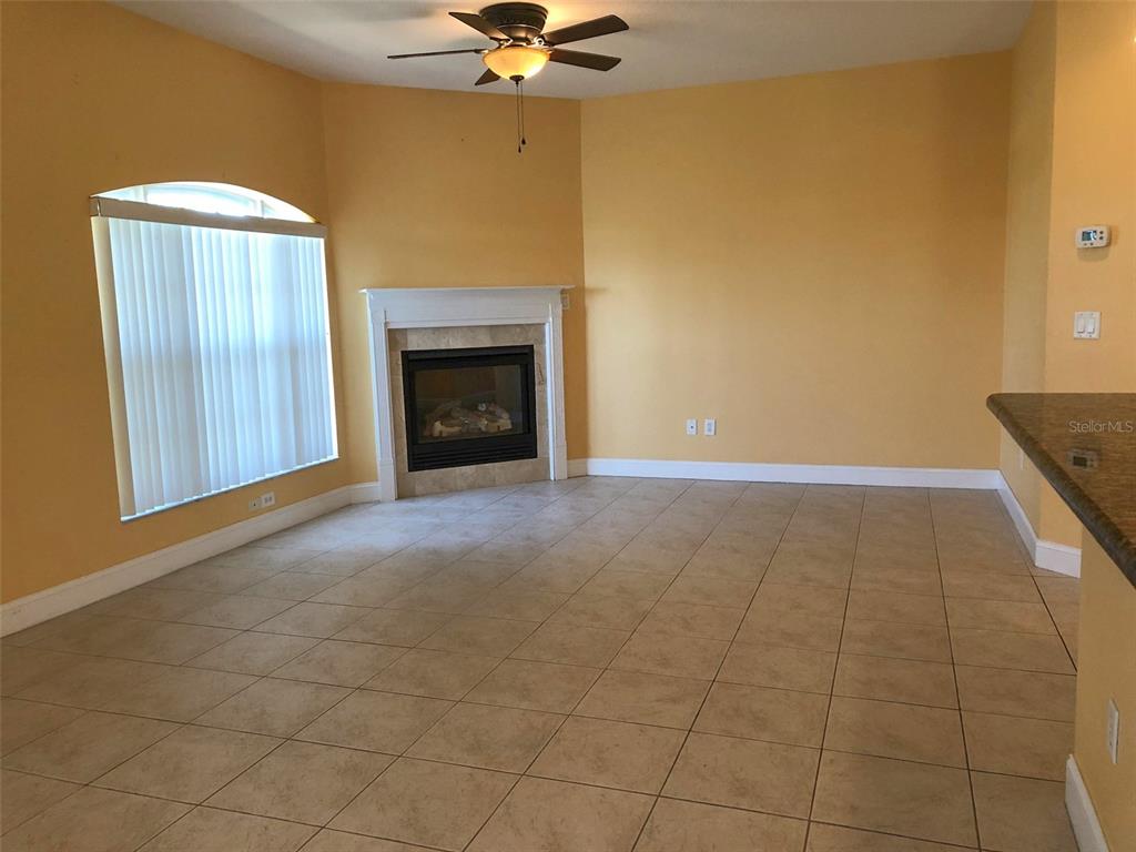 6517 Channelside Drive New Port Richey, FL 34652 - Photo 22 of 31 an empty room with a fireplace and fan