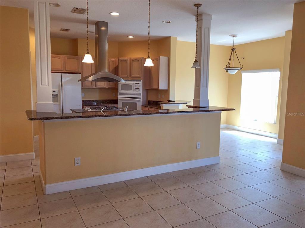 6517 Channelside Drive New Port Richey, FL 34652 - Photo 4 of 31 a kitchen with kitchen island granite countertop a sink a counter top space and cabinets